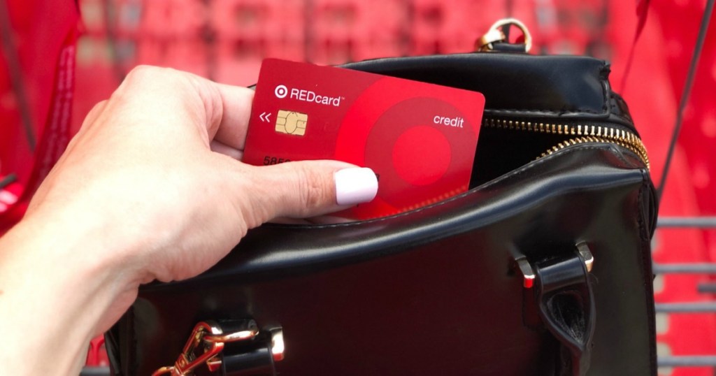 ruční držení cílové červené karty z černé kabelky s červeným vozíkem