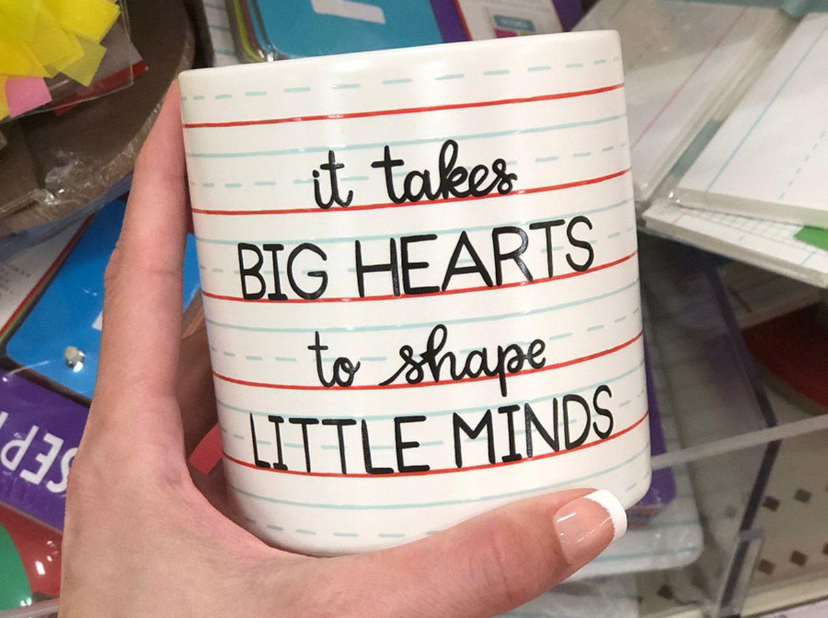 it takes big hearts to shape little minds mug being held in store