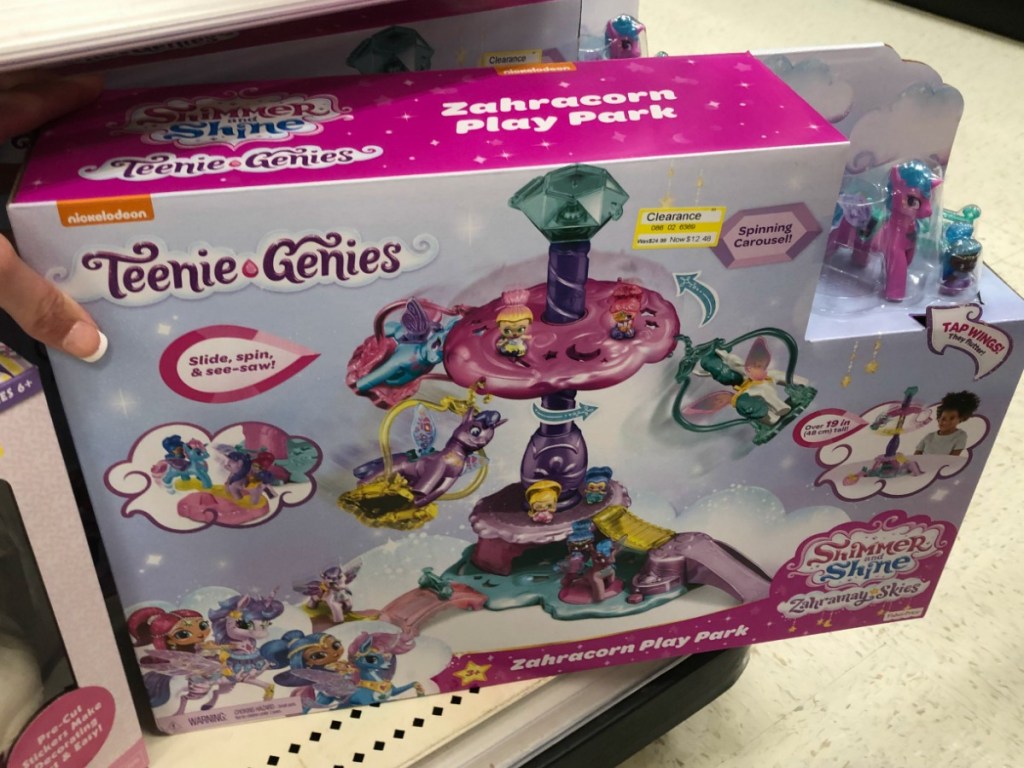 hand holding boxed toy on shelf at store
