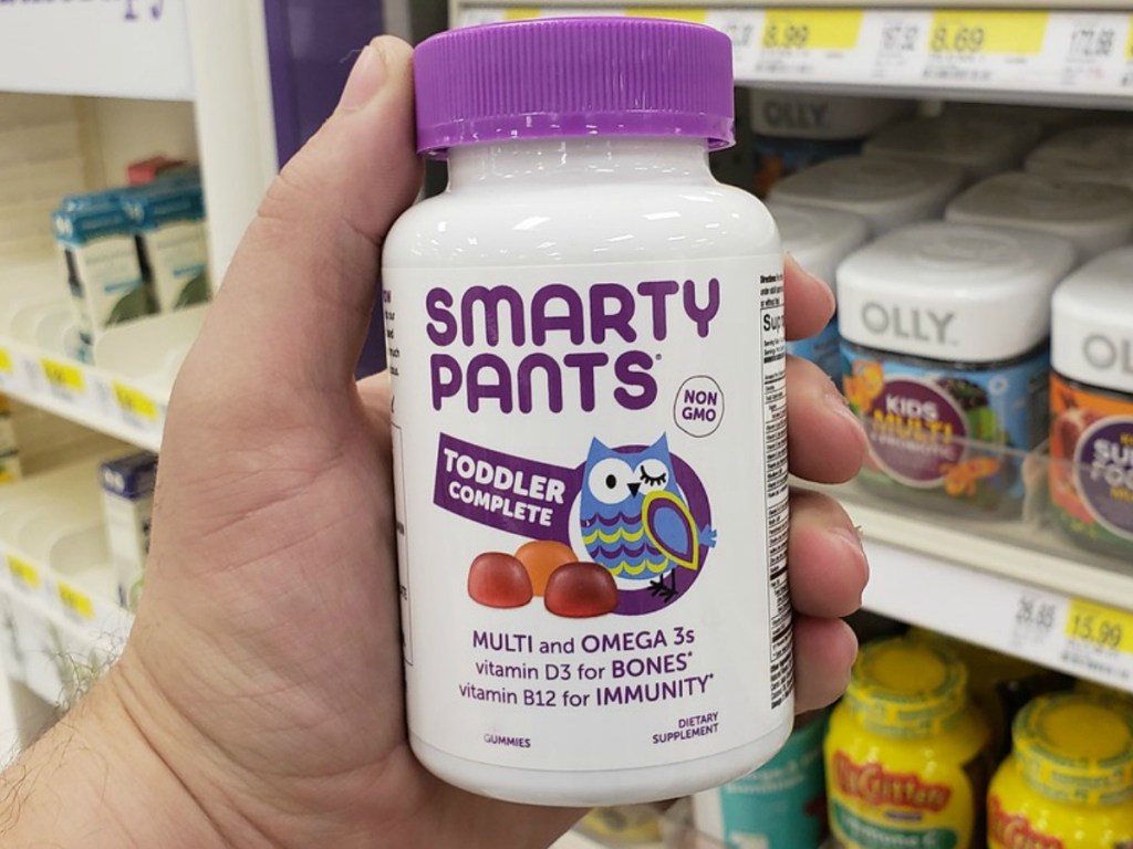 hand holding bottle of toddler vitamins in store