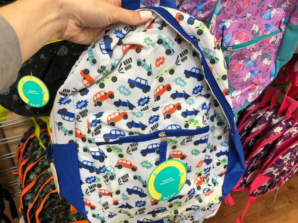 hand holding backpack with cars on it