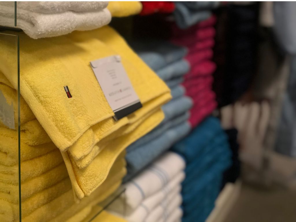 yellow tommy hilfiger towels folded on display in store