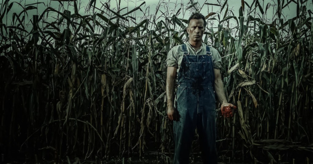 Man in cornfield with bloody hands
