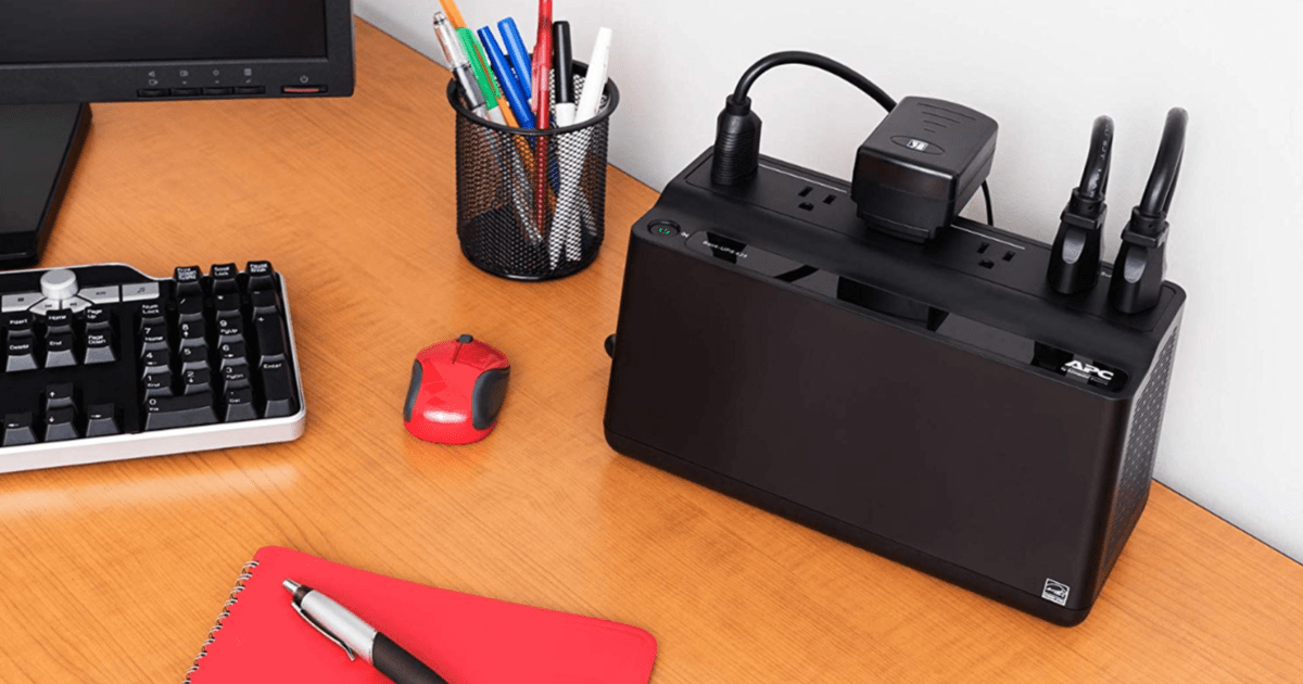 APC UPS Battery Backup & Surge Protector on desk with computer