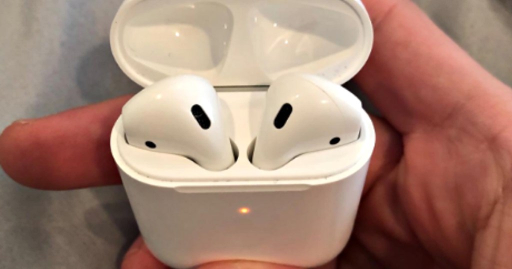 hand holding apple airpods in case