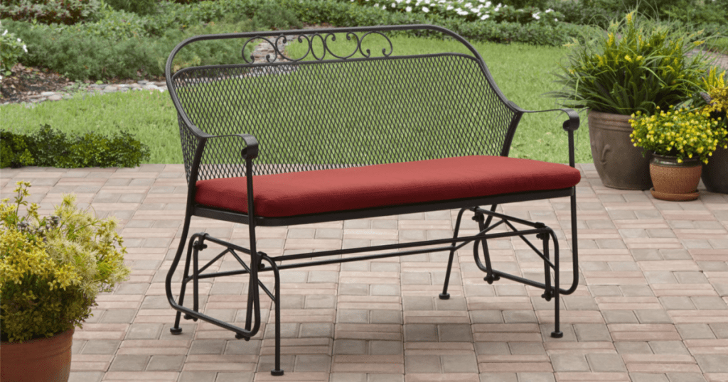 Better Homes & Gardens Clayton Court Outdoor Glider on a patio deck with greenery around