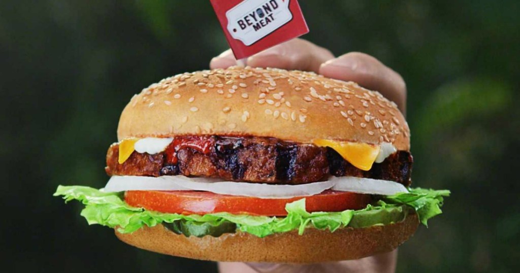 Hand holding a Beyond Meat plant-based burger from Carl's Jr.