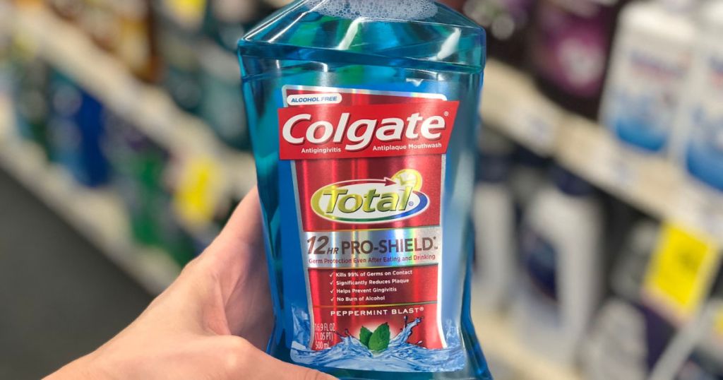 woman's hand holding Colgate Total Mouthwash