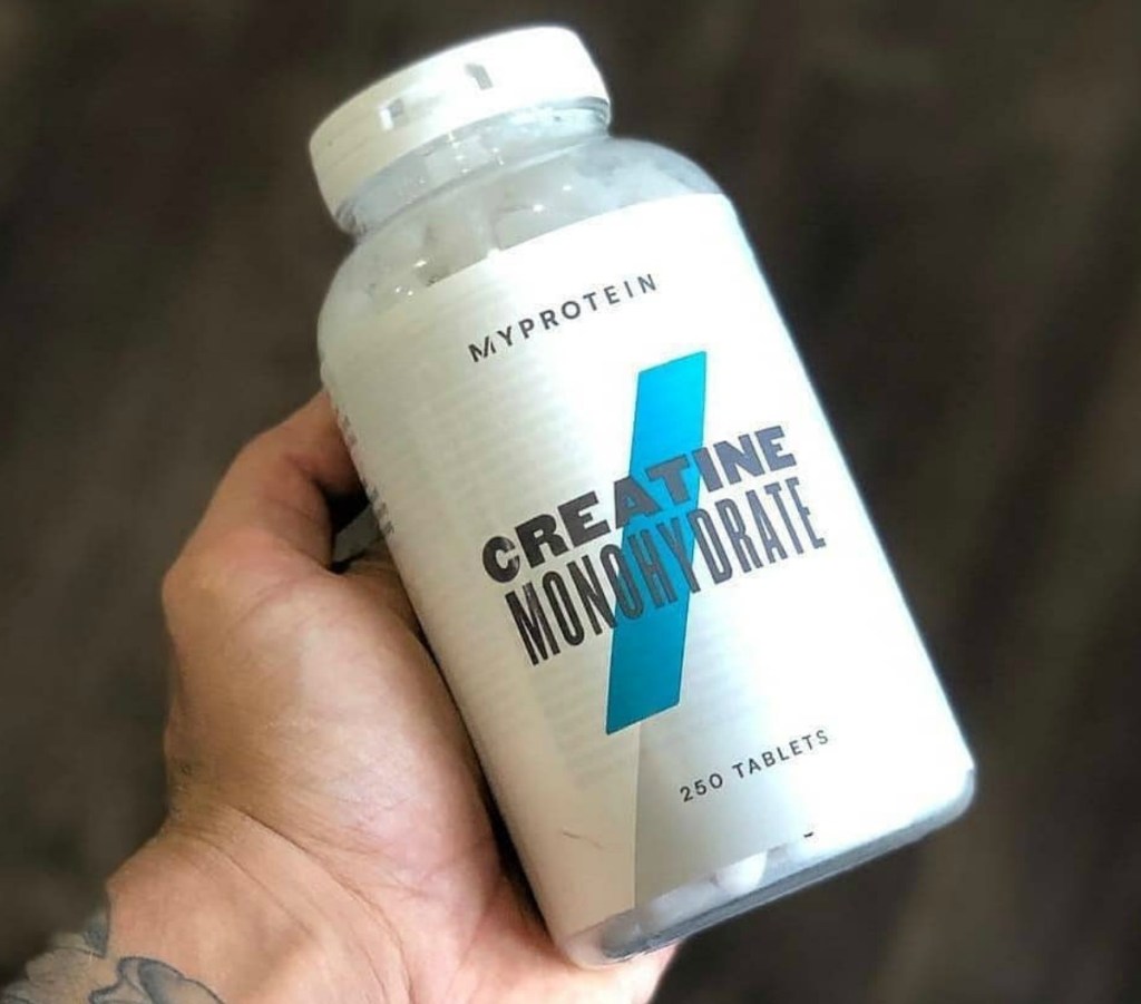 Bottle of Creatine in a 250-Count white bottle in hand