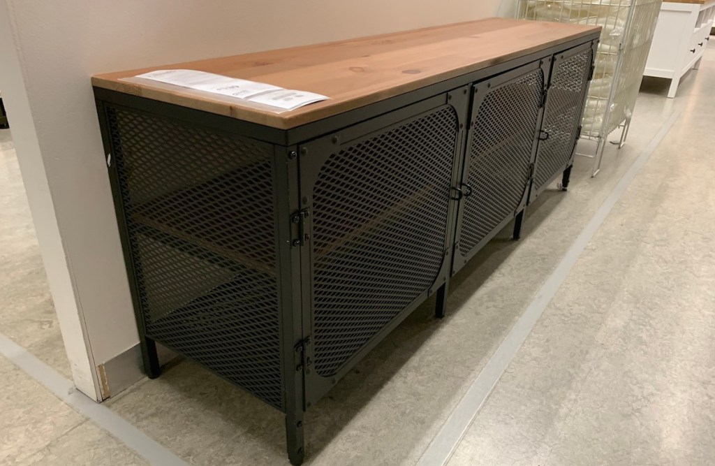 black cage tv stand with wood top in IKEA store