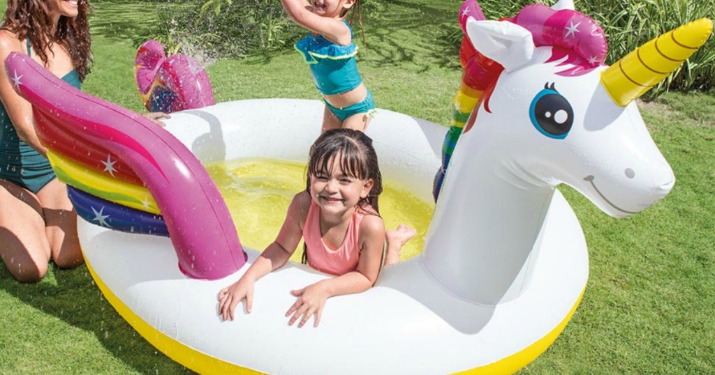 Unicorn themed pool in backyard with kids and mom playing
