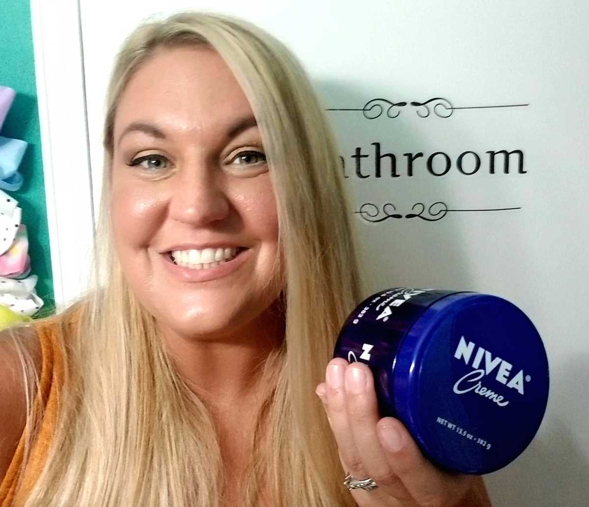 woman holding blue jar of NIVEA creme