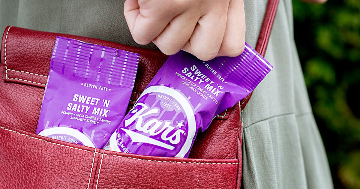 two bags of Kars nuts sweet n salty mix in woman's purse