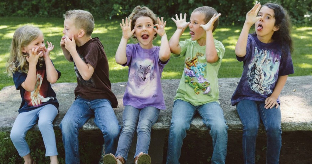 Five kids wearing various styles of The Mountain tees outside and making silly faces