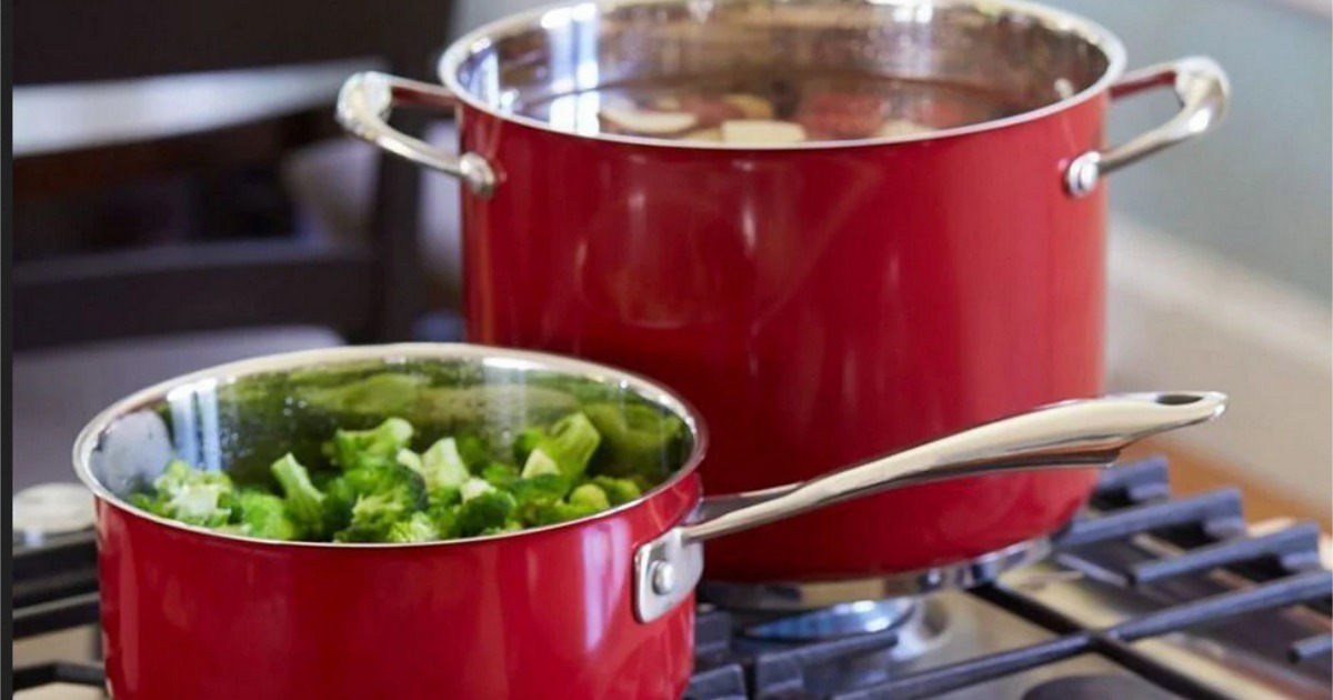 two KitchenAid Cookware pots on a stove top with food