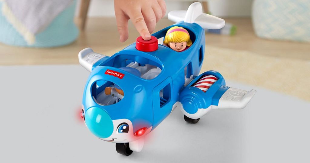 child hand pushing button on Little People Travel Together Airplane
