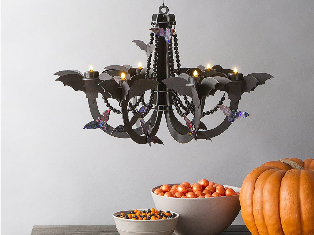 bat chandelier with table full of candy and a pumpkin