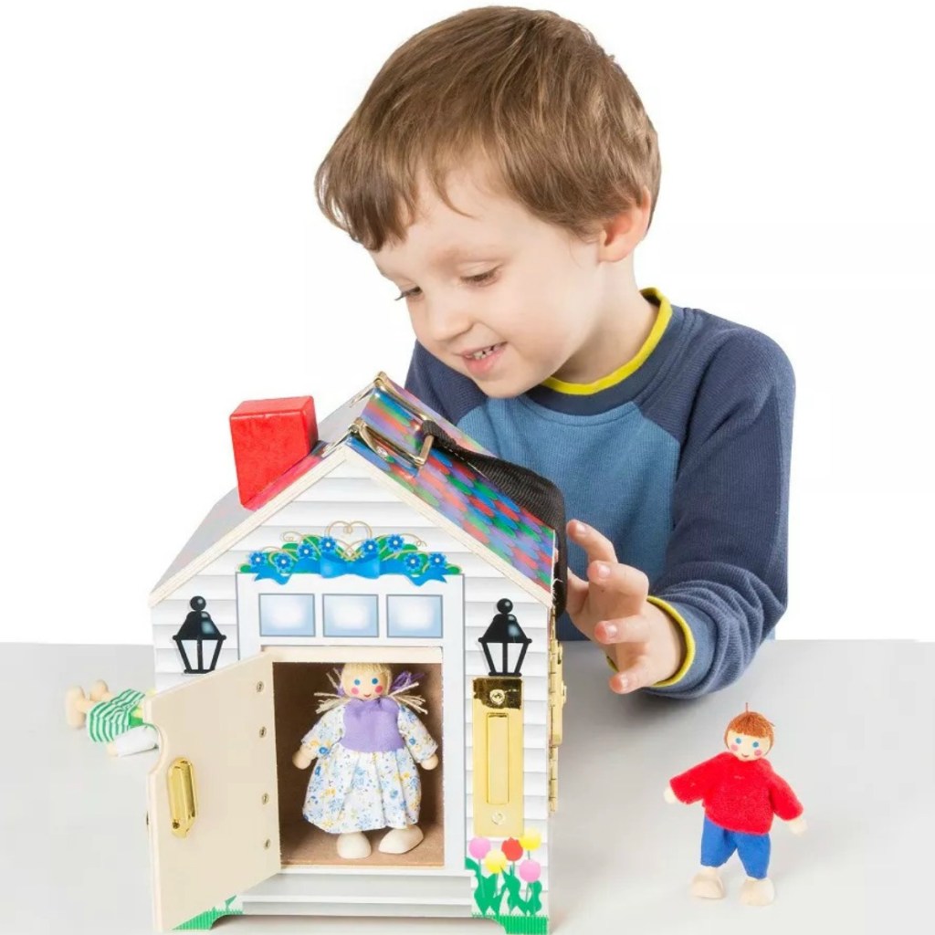Boy playing with Melissa & Doug Take-Along Wooden Doorbell Dollhouse 