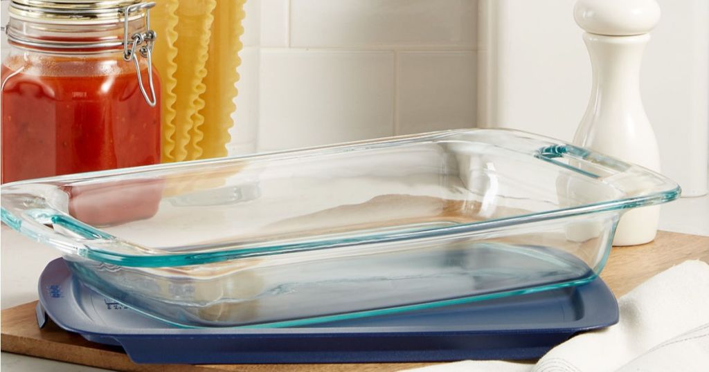 pyrex covered baking dish with lasagna noodles and sauce in the background