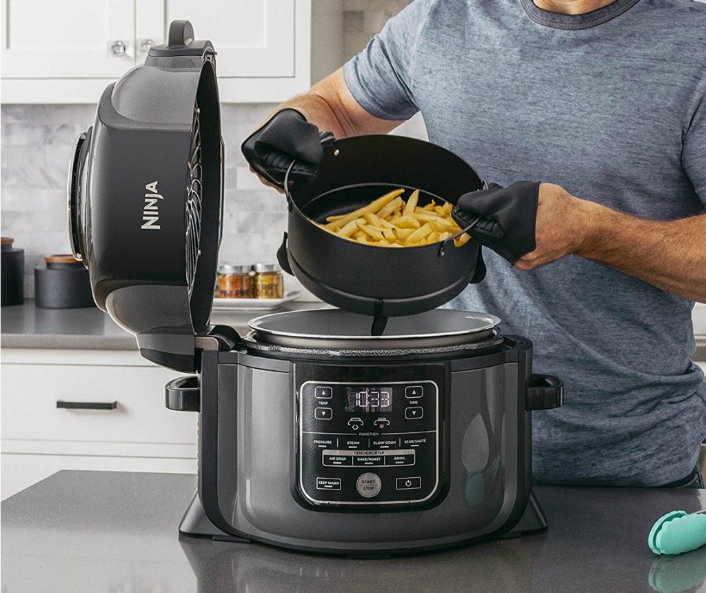 Man putting fries in an air fryer on the counter