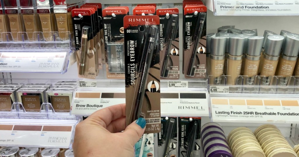 Rimmel Brow liner held up in front of Target Cosmetics wall