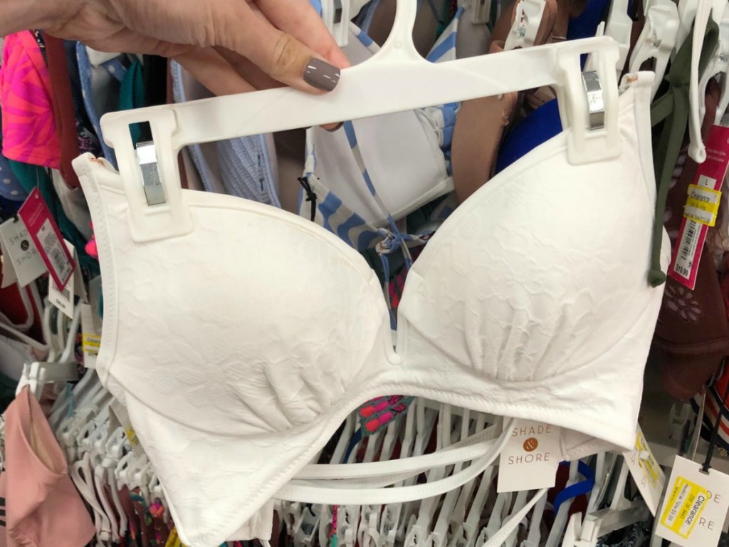 hang holding white bikini top in store
