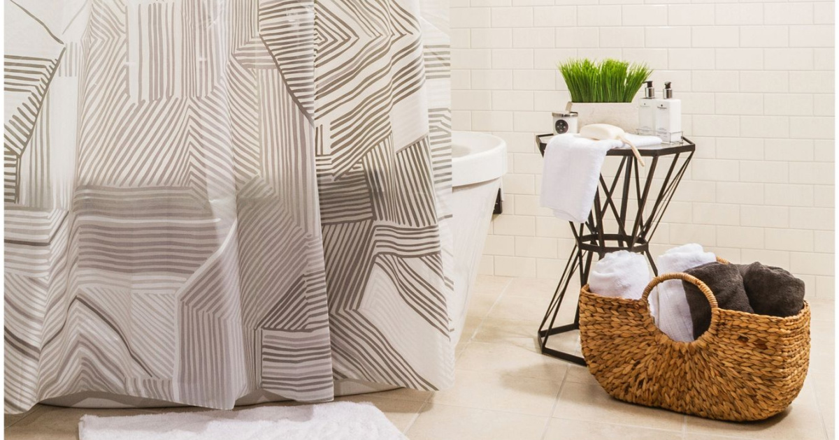 printed shower curtain in bathroom next to table and basket