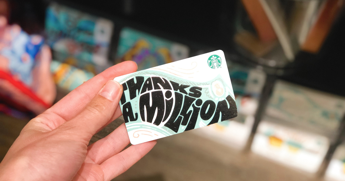 hand holding starbucks gift card with gift cards blurred in the background