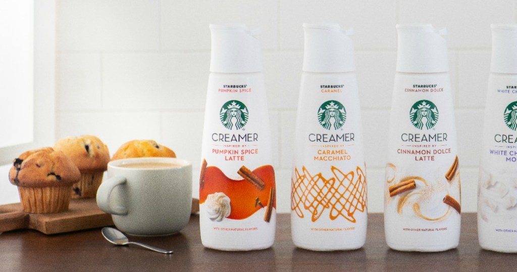 Starbucks-inspired creams in various flavors on counter top with muffins and mug of coffee