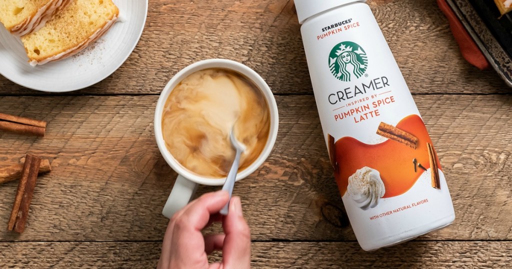 Starbucks Pumpkin Spice Latte Creamer on table next to cup of coffee