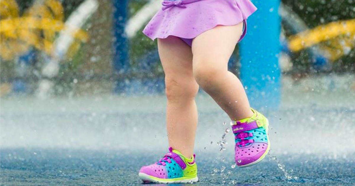 toddler girl running through splash pad wearing phibian sneakers