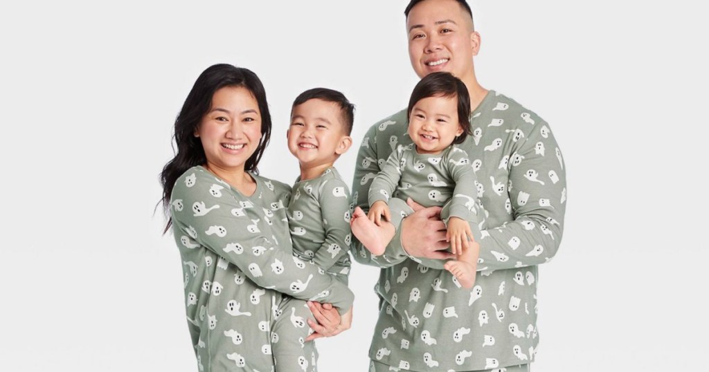 mom, dad and kids all wearing matching halloween pajamas with ghosts