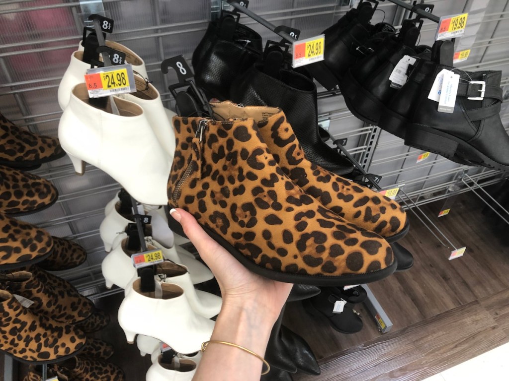 hand holding women's boots at Walmart