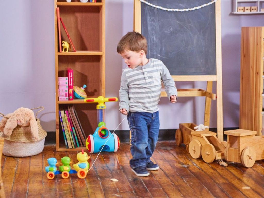 boy pulling Tomy Toomies Quack Along ducks in room