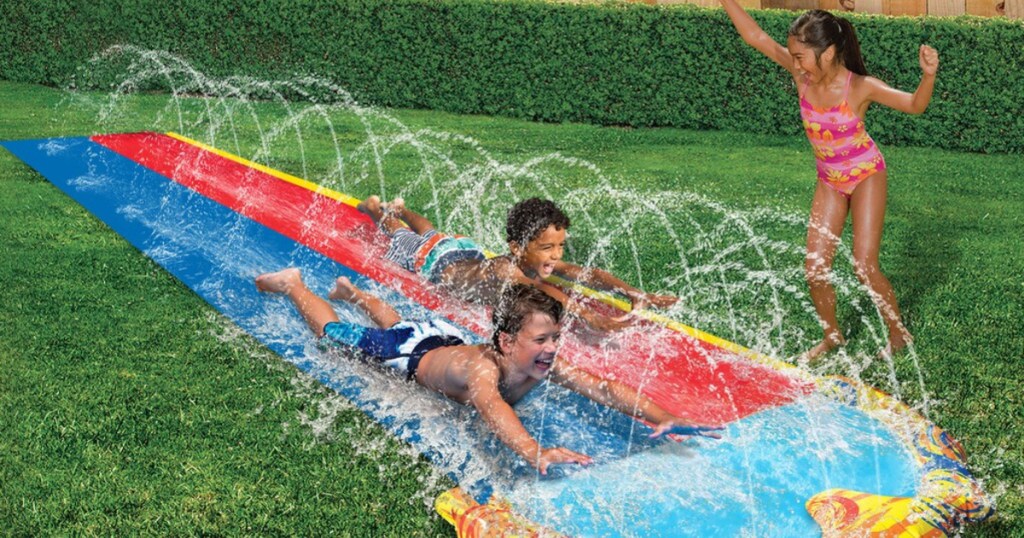 kids playing on slip n slide in yard