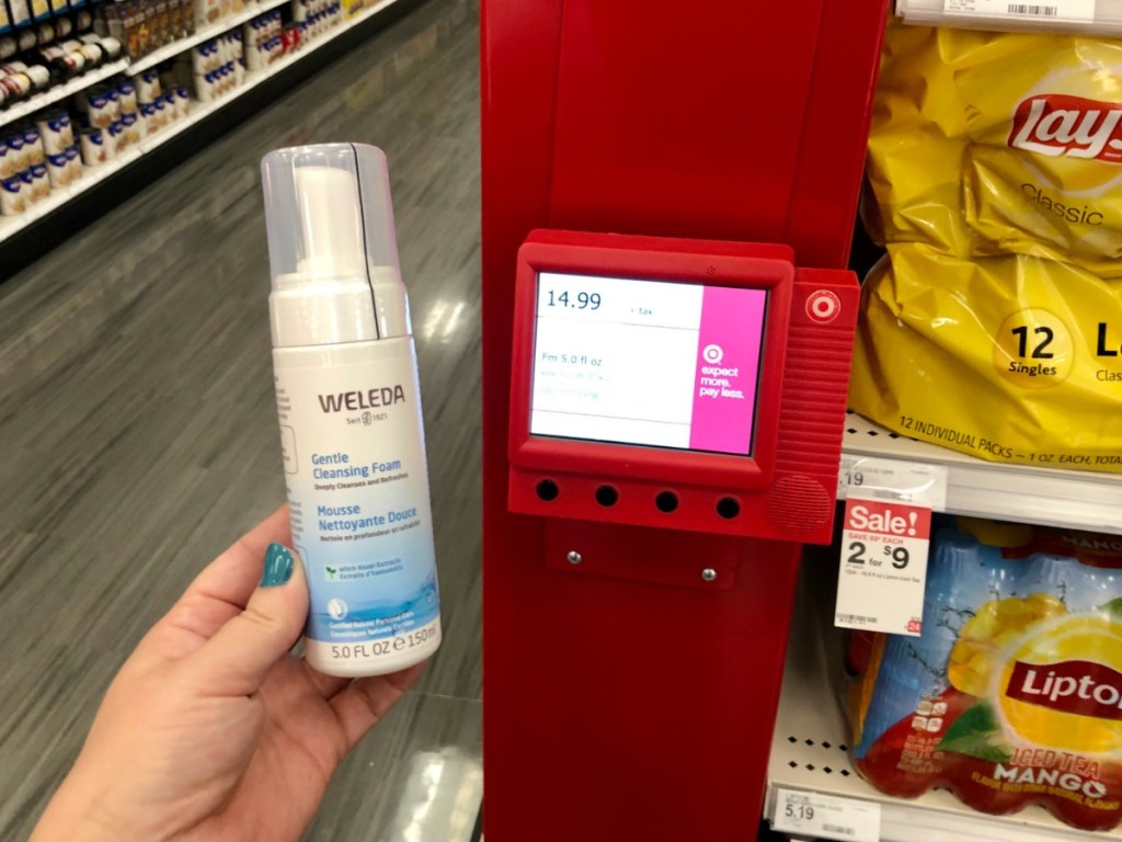 hand holding weleda cleansing foam up to price checker in store