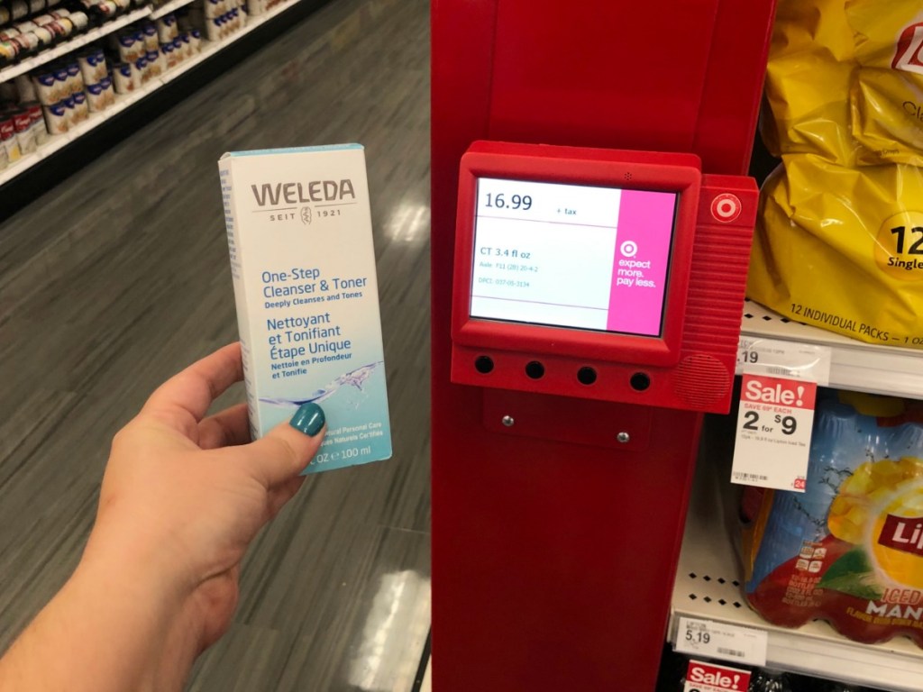 hand holding weleda toner up to price checker in store