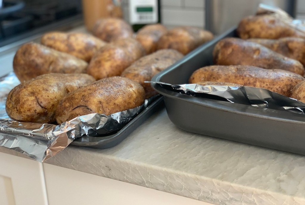 baked potatoes sitting on foil pans