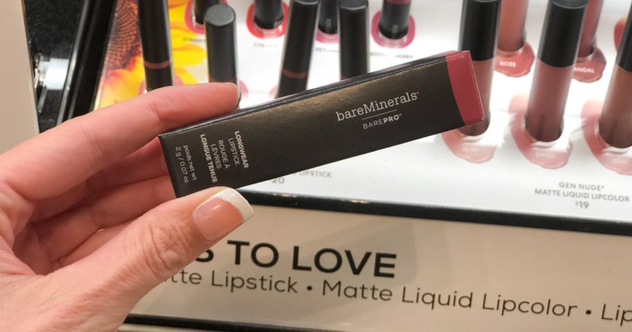 hand holding Bare Minerals matte lipstick