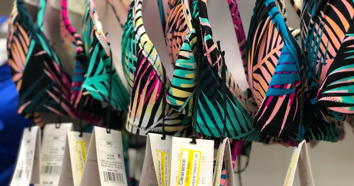 a row of bikini tops in store with clearance tags