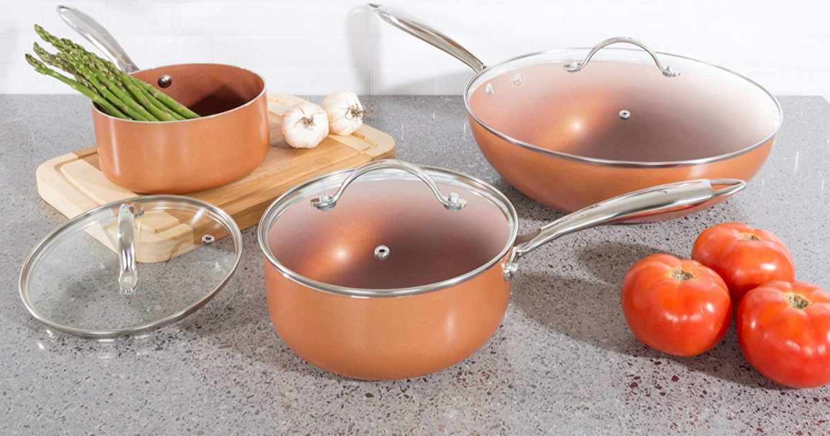 copper cookware set on counter with vegetables