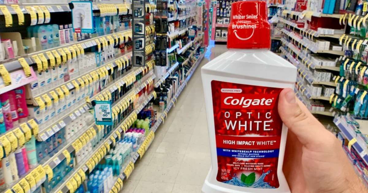 hand holding bottle of colgate optic white mouthwash walgreens