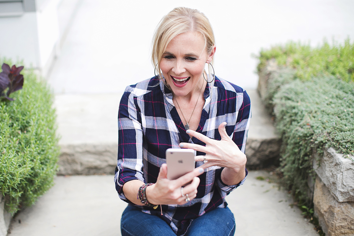 woman looking at iphone excited and happy