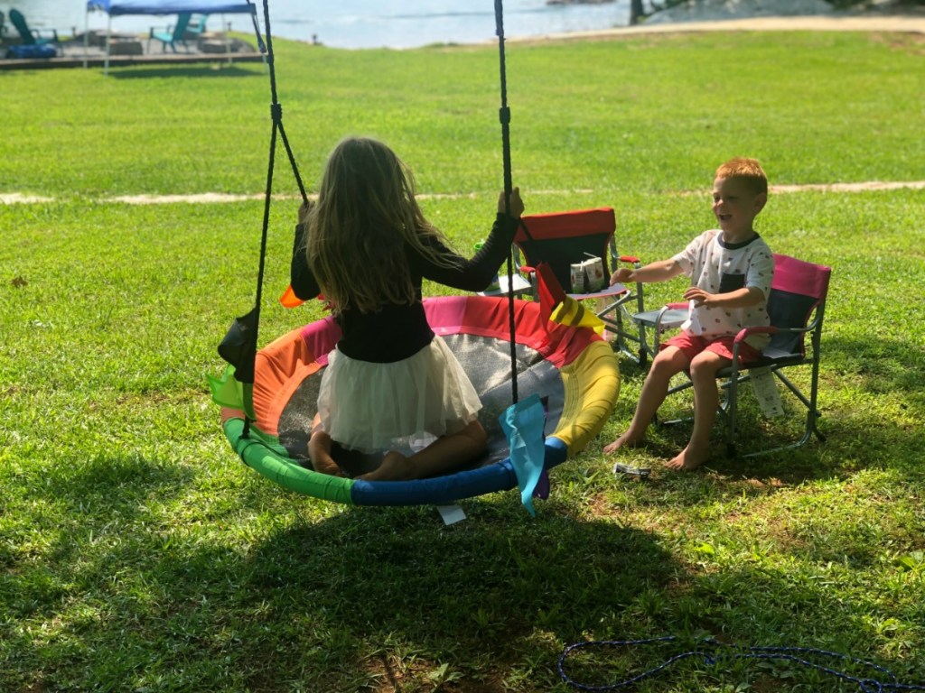 two kids swinging on a saucer swing