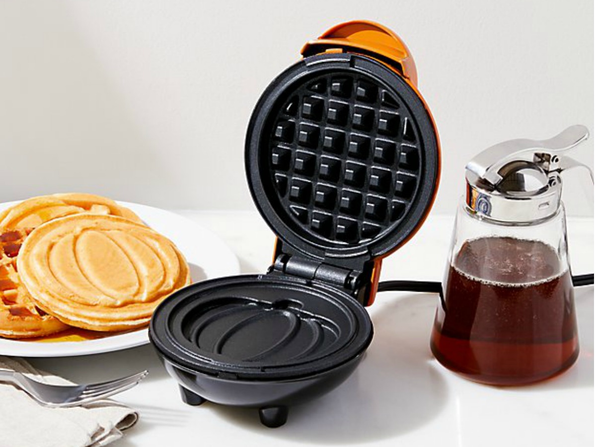 Waffle make with pumpkin design by plate of waffles and syrup