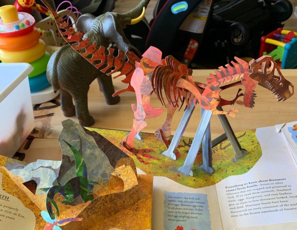 pop-up book with dinosaur coming out of it