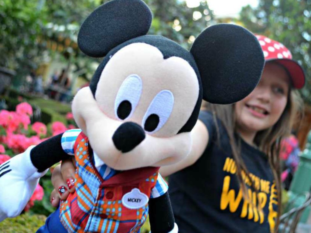 girl holding Mickey Mouse toy