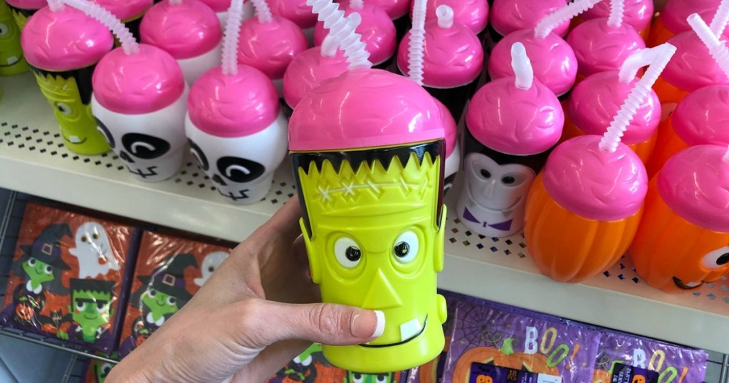 hand holding plastic cup that looks like frankenstein