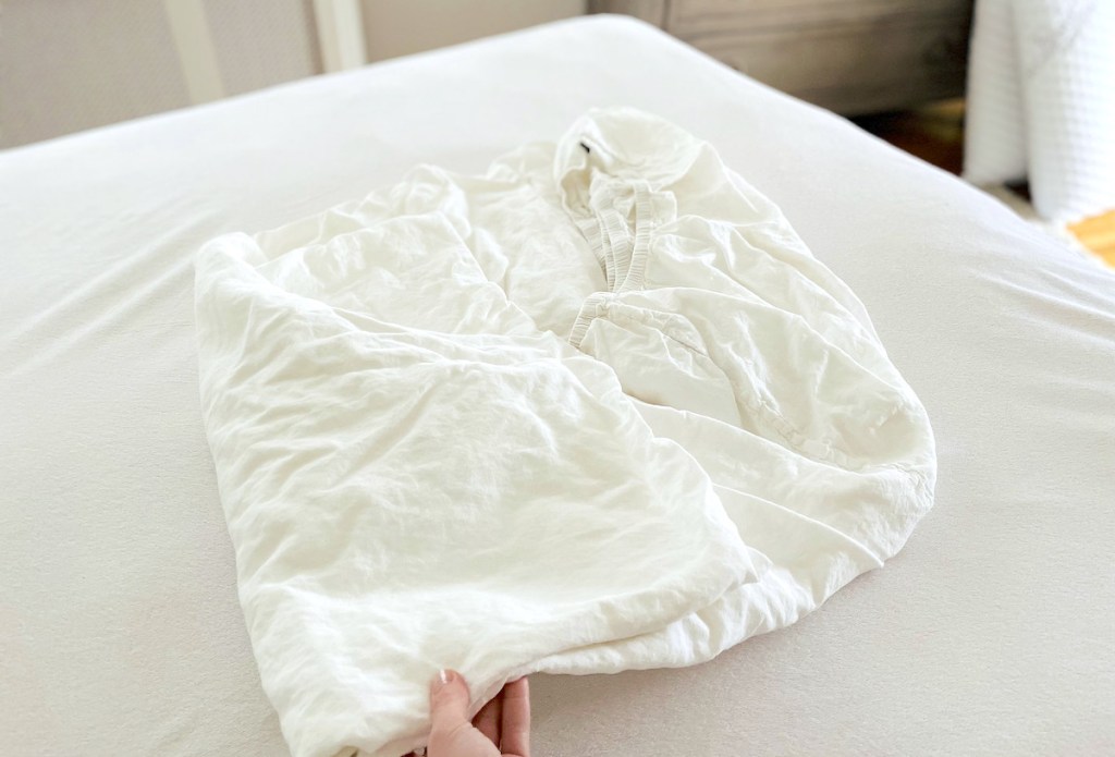 half folded white fitted sheet on bed