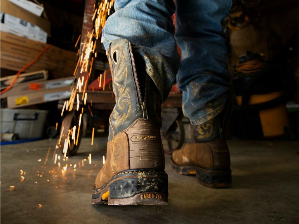 guy wearing boots with sparks surrounding him in a workshop